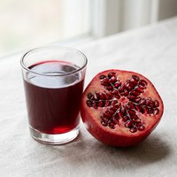 Red pomegranate and a glass of pomegranate juice
